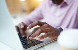 man typing on laptop